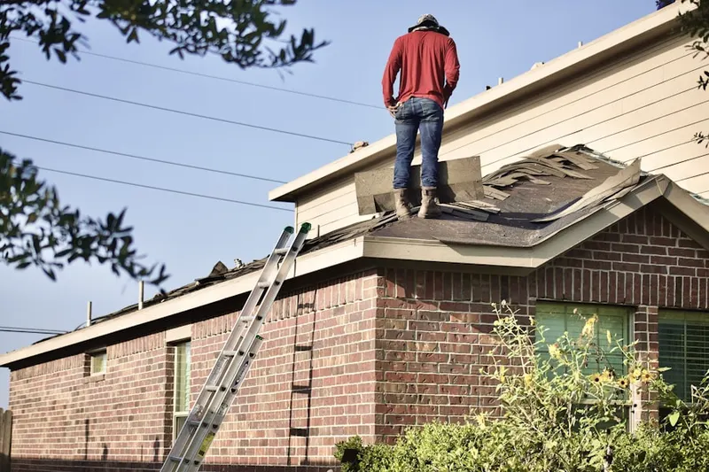 Professional roofer working on a residential roof in Flinton